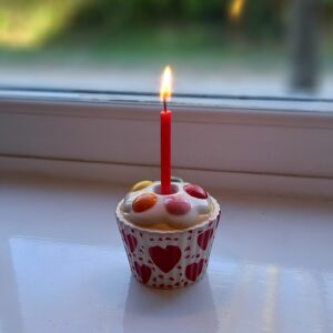 Ceramic candle holder shaped like a cup cake with a lit candle in the centre