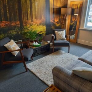 therapy room at Counselling West Bridgford, Pavilion House in Nottingham with a sofa and two arm chairs, forest wallpaper. A room for therapy in Nottingham