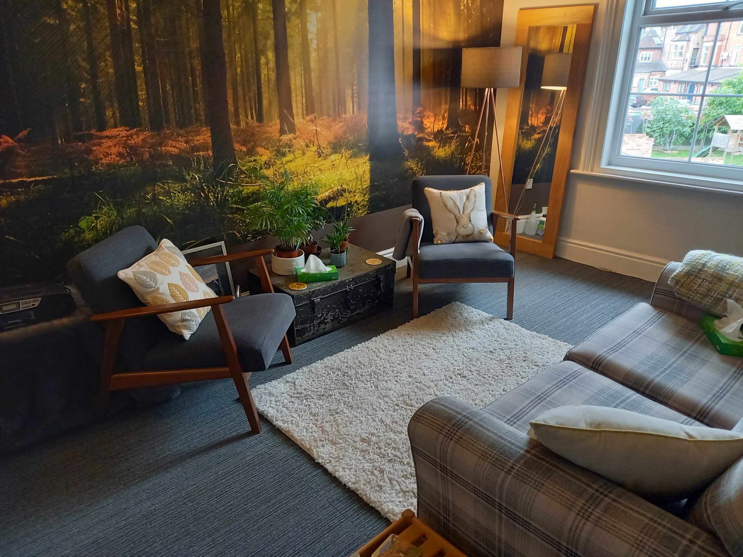 therapy room at Counselling West Bridgford, Pavilion House in Nottingham with a sofa and two arm chairs, forest wallpaper. A room for therapy in Nottingham