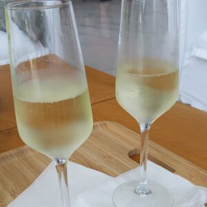 Two champagne flutes half-filled with champagne; image for tool for meaningful relationships post