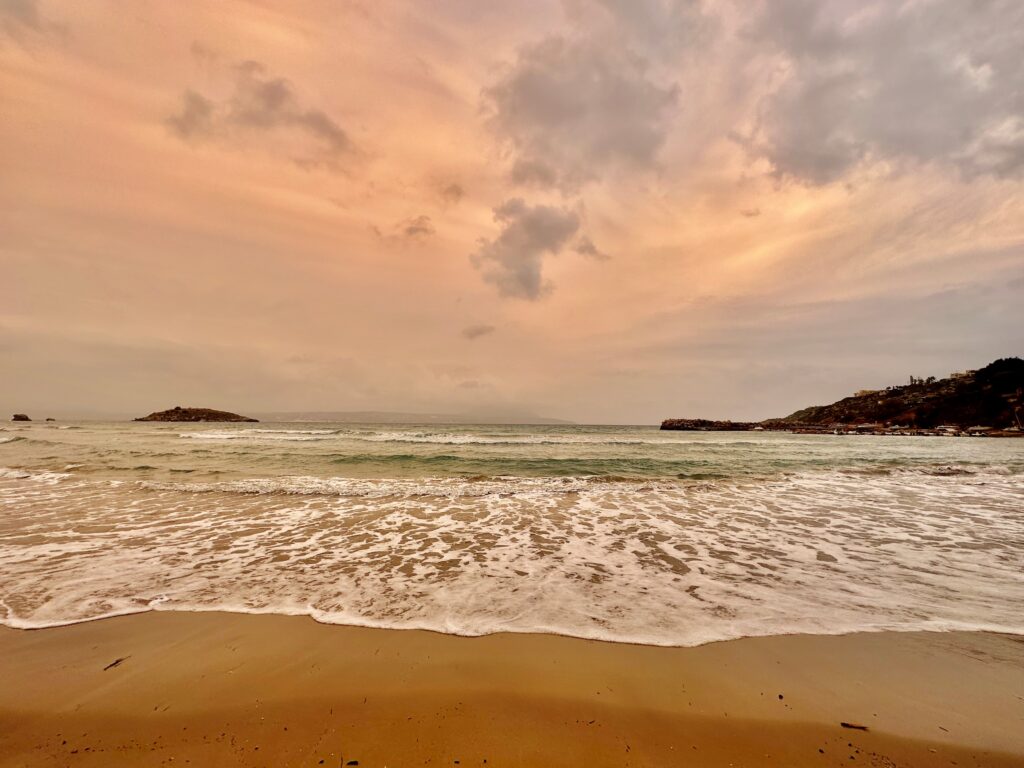 Beach in foreground, orange sky at sunset