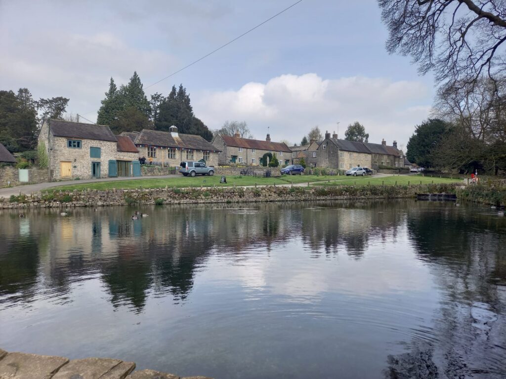 Small lake in front of row of old english cottages. Image for article on how to improve your communication