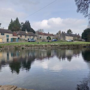 Small lake in front of row of old english cottages. Image for article on how to improve your communication