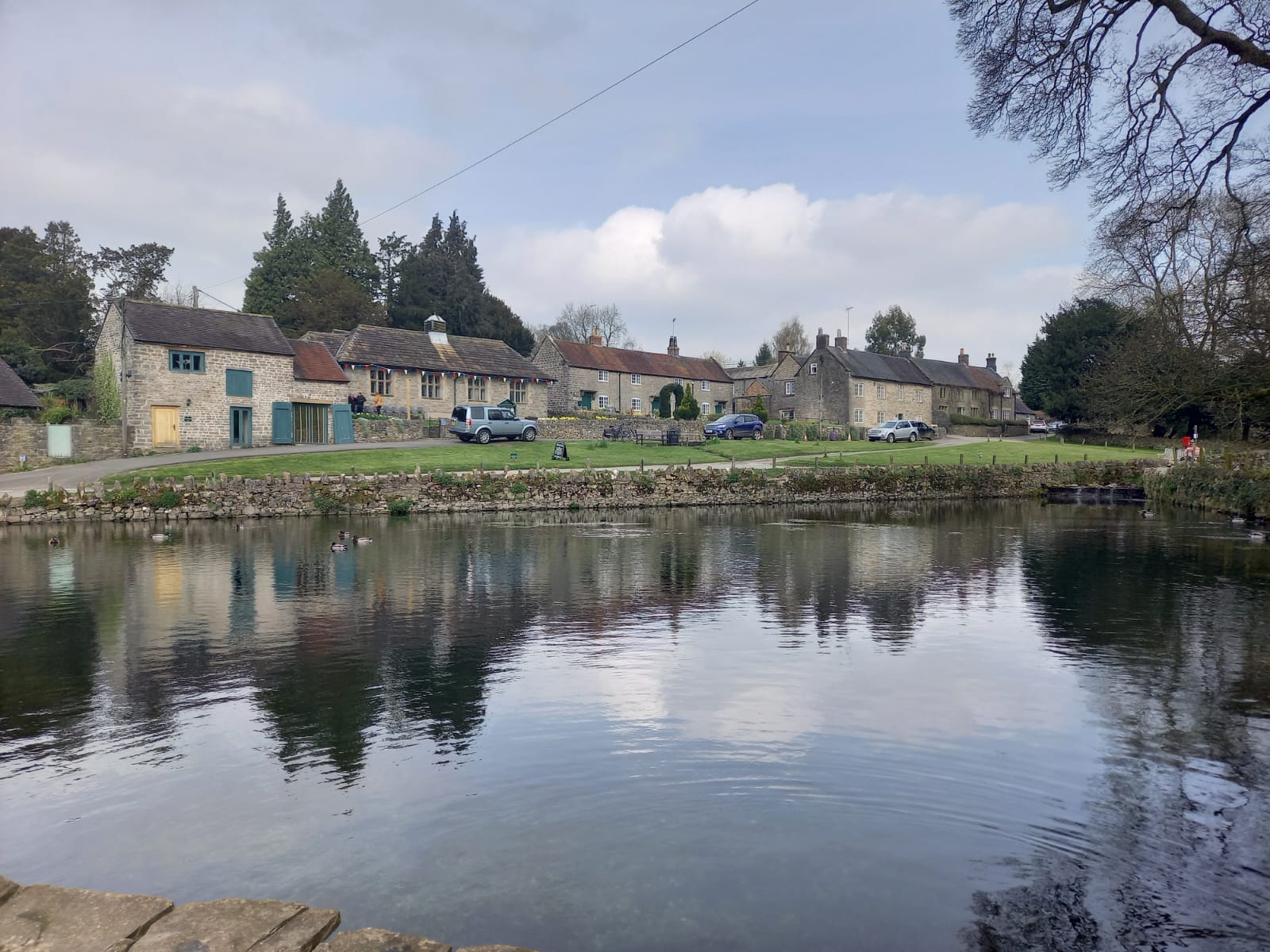 Small lake in front of row of old english cottages. Image for article on how to improve your communication